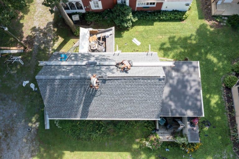 Men performing a roof replacement on a house