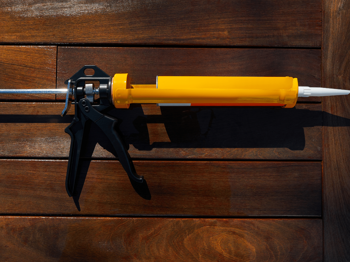 caulking gun with a black silicon background