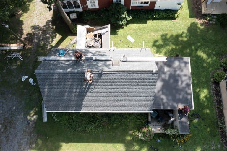 men working on a winter roof replacement